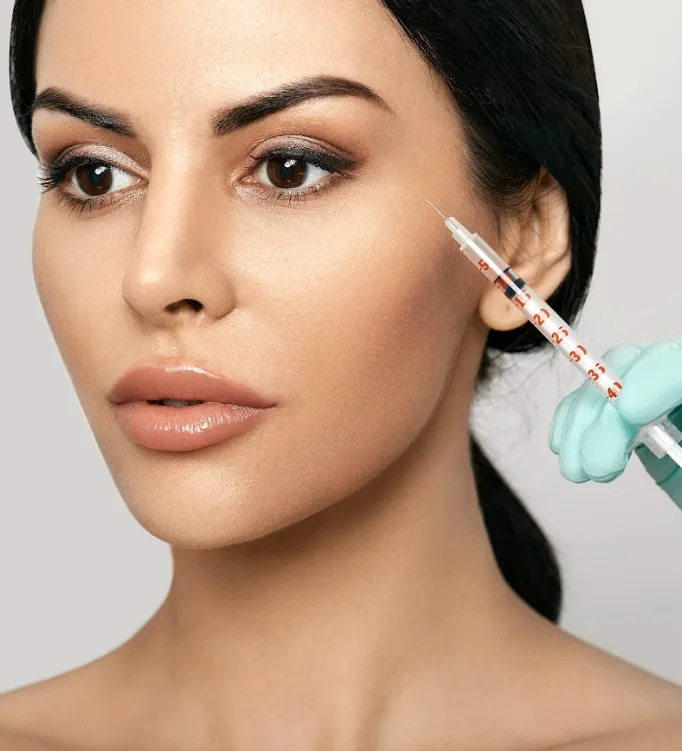 Woman receiving injections near cheek, Auburn, MA., Client reviewing personalized facial aesthetics treatment plan during consultation in Cambridge clinic