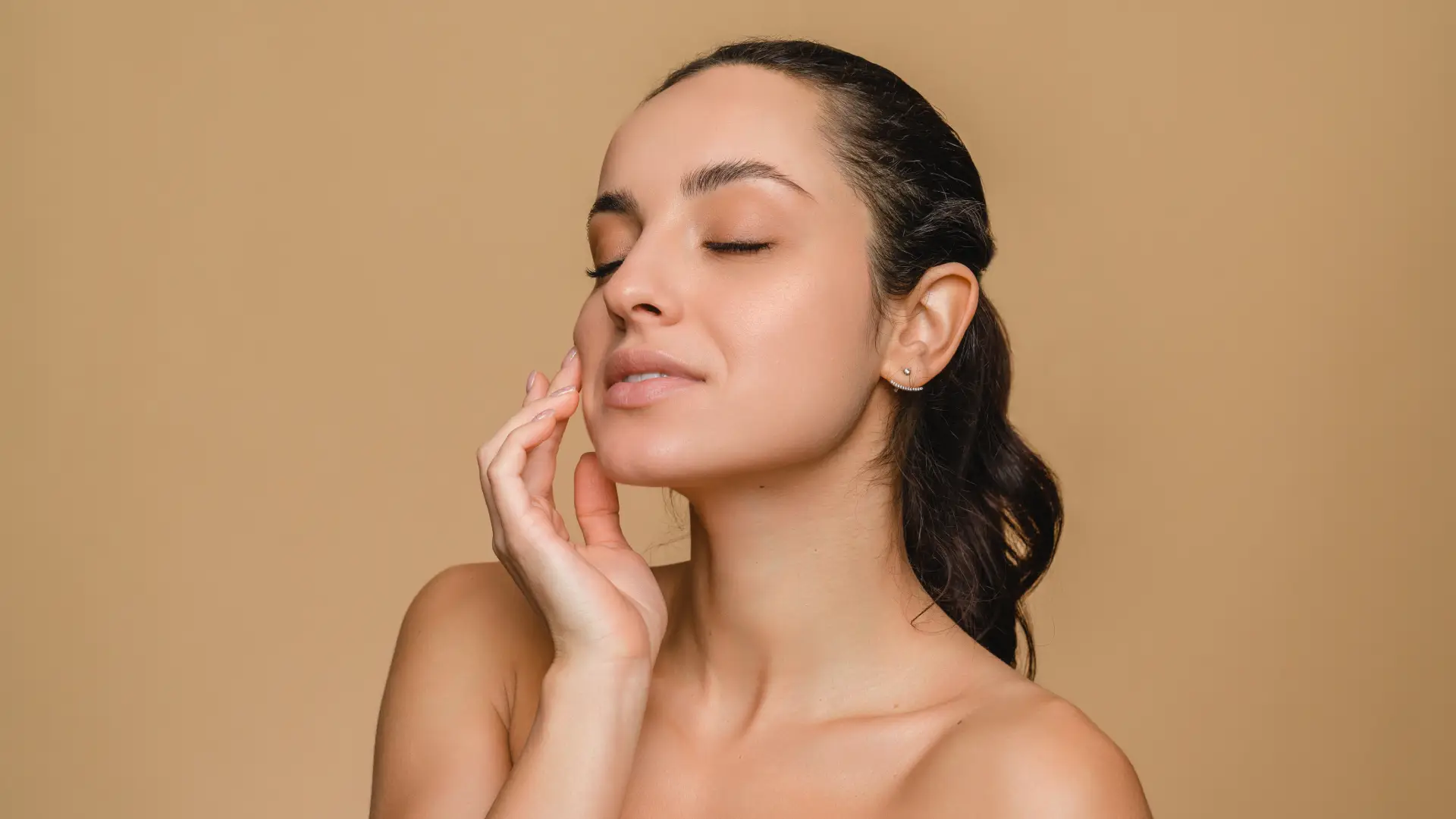 Young woman applying moisturizer for radiant skin in Auburn, MA