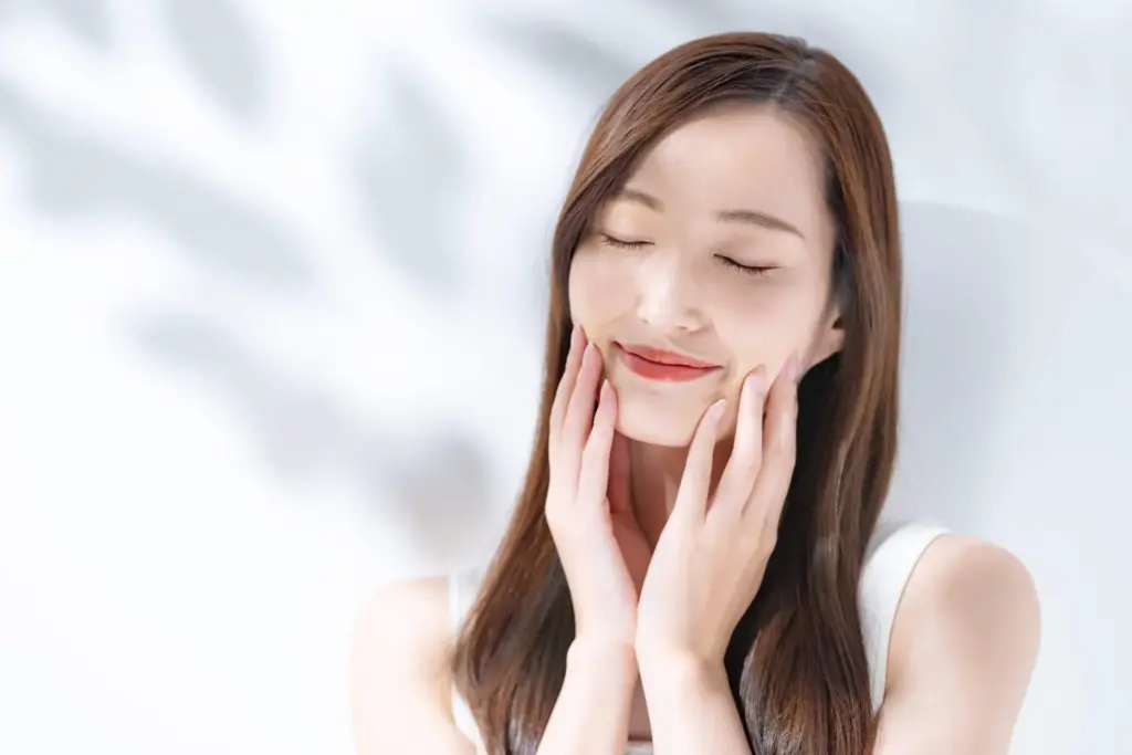 Woman gently touching her face, Auburn, MA clinic.