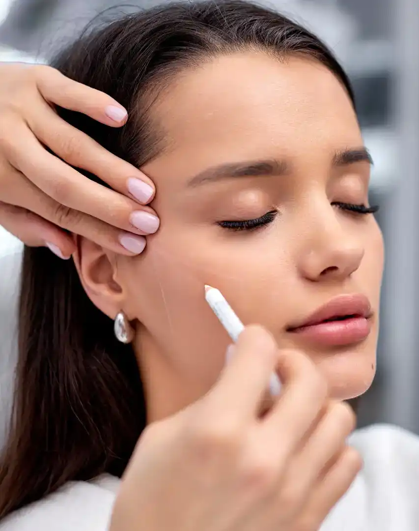 Close up of aesthetic injection procedure in Auburn, MA., Aesthetic provider evaluating facial symmetry and skin quality with clinical precision