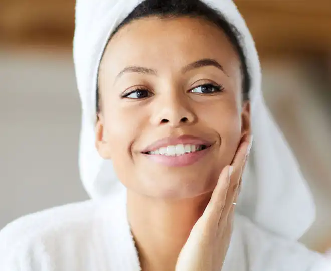 Smiling woman enjoying post-facial glow at medspa in Auburn, MA, Aesthetic specialist assessing skin texture and facial contours using advanced clinical techniques