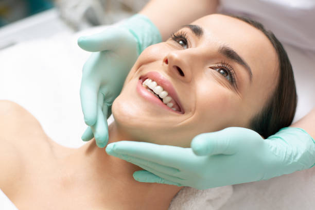 Experienced aesthetic provider evaluating facial skin with focused attention and professional tools
